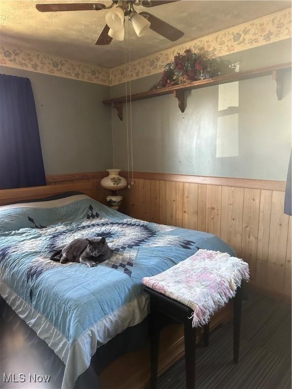 167 Andover Rd, Woodsfield, OH 43793 - bedroom featuring wainscoting, wooden walls, and a ceiling fan