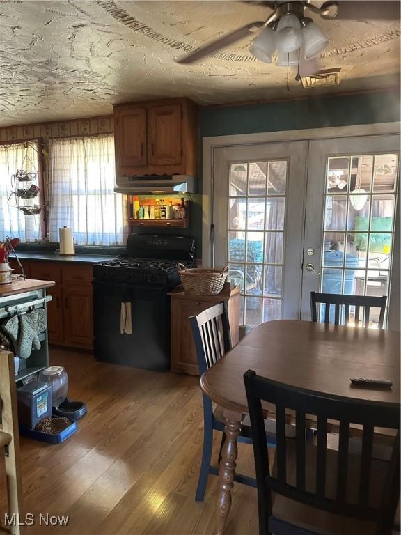 167 Andover Rd, Woodsfield, OH 43793 - kitchen featuring black gas stove, under cabinet range hood, a ceiling fan, and brown cabinets