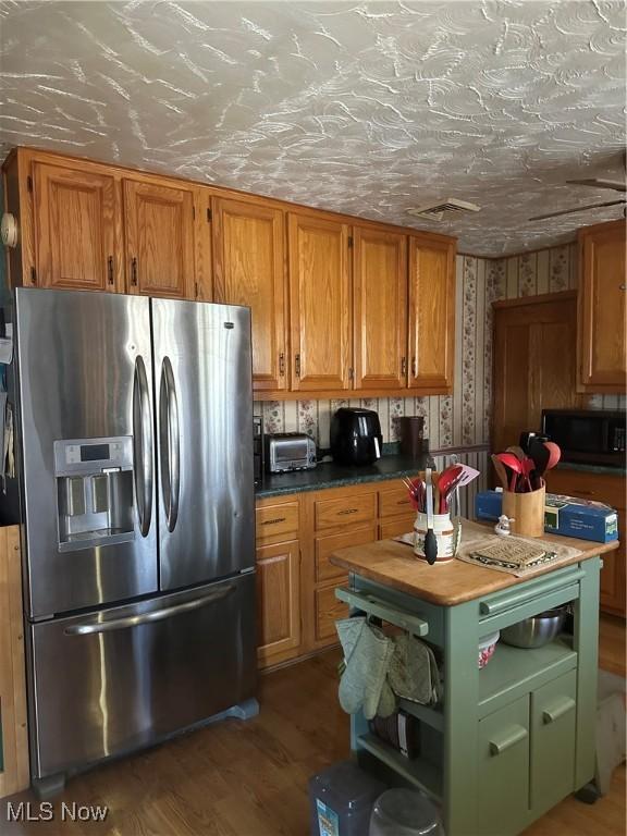 167 Andover Rd, Woodsfield, OH 43793 - kitchen with stainless steel refrigerator with ice dispenser, black microwave, wood finished floors, brown cabinetry, and open shelves