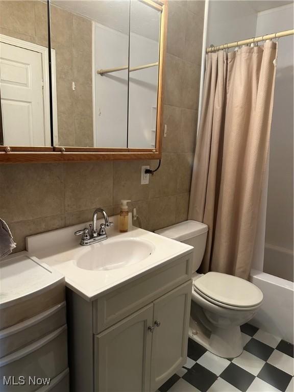 167 Andover Rd, Woodsfield, OH 43793 - full bathroom featuring tile patterned floors, vanity, tile walls, shower / bathtub combination with curtain, and toilet