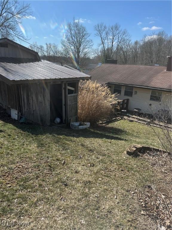 167 Andover Rd, Woodsfield, OH 43793 - rear view of house featuring a yard
