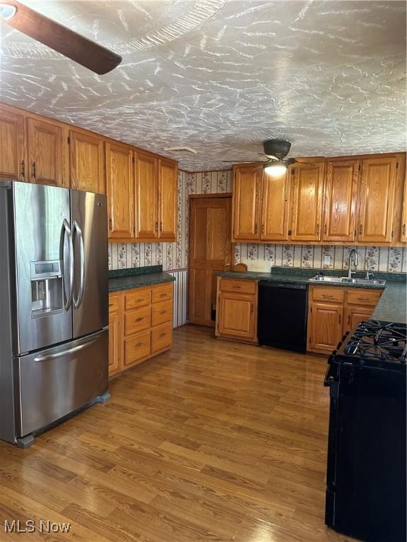 167 Andover Rd, Woodsfield, OH 43793 - kitchen with black appliances, a sink, brown cabinets, and light wood finished floors