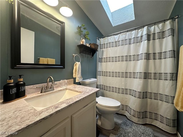 full bathroom with vanity, a shower with shower curtain, vaulted ceiling with skylight, and toilet