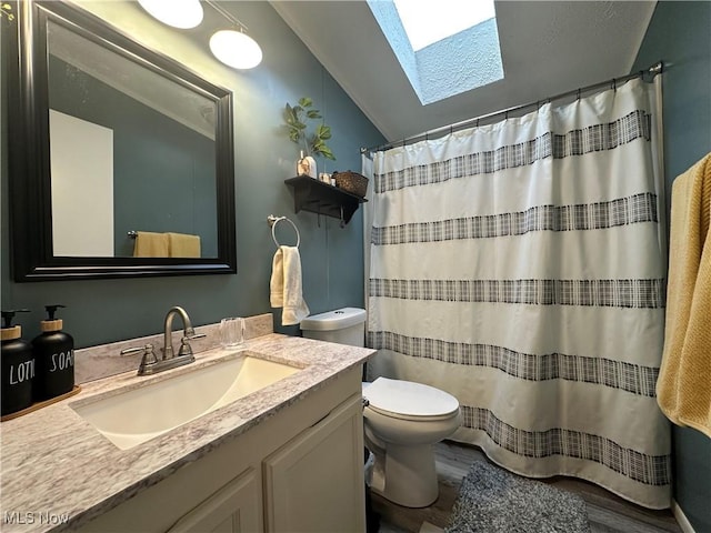 full bath featuring a shower with curtain, vaulted ceiling with skylight, toilet, and vanity