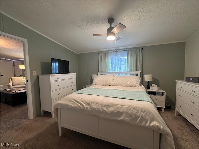 bedroom featuring lofted ceiling, a ceiling fan, dark carpet, and a textured ceiling