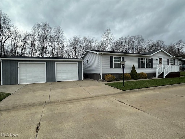 view of front of property featuring an outdoor structure, a garage, and a front lawn