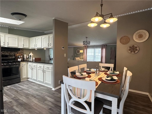 dining area featuring a chandelier, baseboards, and dark wood-style flooring