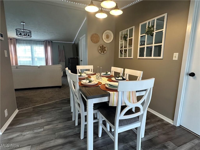 dining space featuring wood finished floors, baseboards, and a chandelier