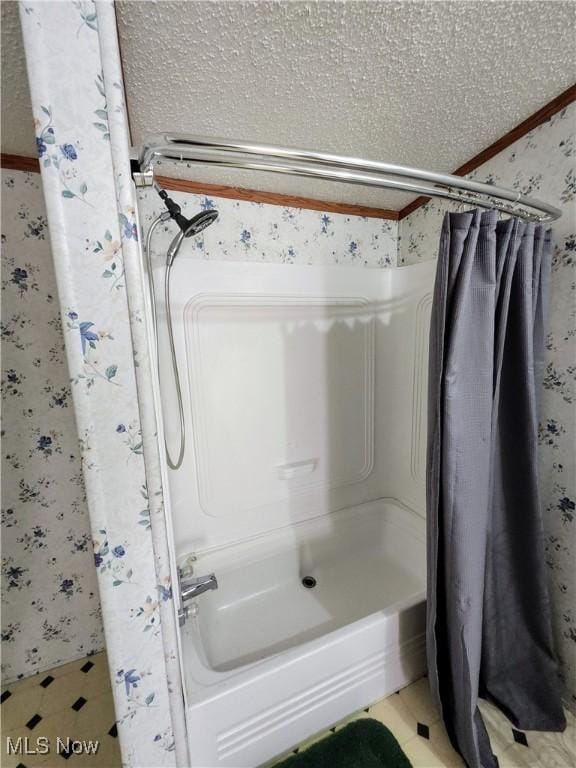 full bathroom featuring wallpapered walls and a textured ceiling