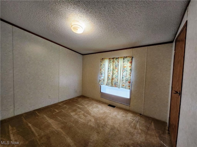 carpeted empty room featuring ornamental molding, visible vents, and a textured ceiling