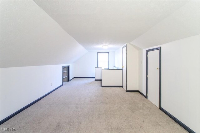 15921 Cloverside Ave, Cleveland, OH 44128 - additional living space featuring vaulted ceiling, baseboards, and a textured ceiling