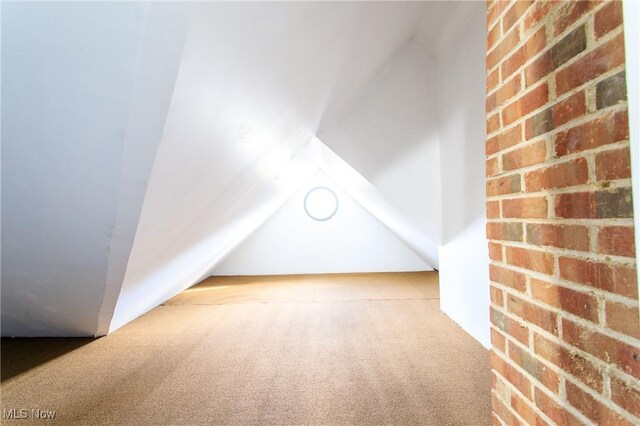 15921 Cloverside Ave, Cleveland, OH 44128 - additional living space with carpet floors, lofted ceiling, and brick wall