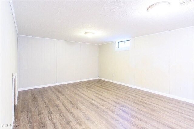 15921 Cloverside Ave, Cleveland, OH 44128 - below grade area with visible vents, a textured ceiling, baseboards, and wood finished floors