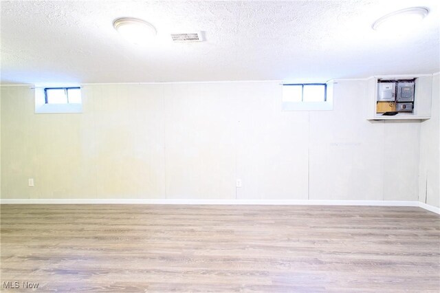 15921 Cloverside Ave, Cleveland, OH 44128 - below grade area with wood finished floors, visible vents, and a textured ceiling