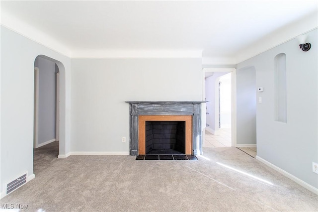15921 Cloverside Ave, Cleveland, OH 44128 - unfurnished living room with visible vents, baseboards, carpet, a fireplace, and arched walkways