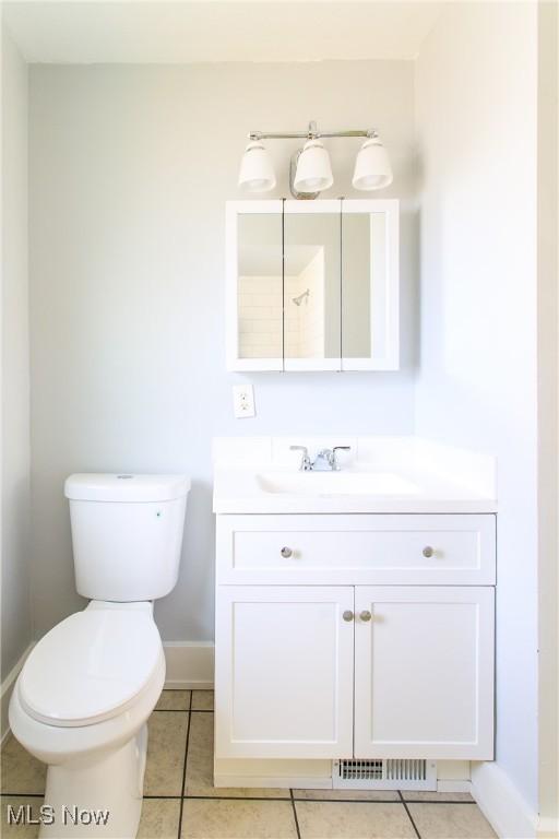 15921 Cloverside Ave, Cleveland, OH 44128 - half bath with vanity, tile patterned floors, toilet, and baseboards
