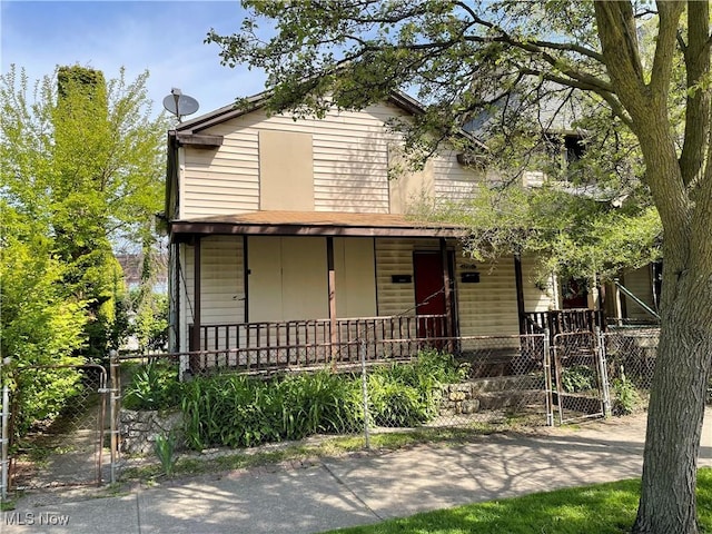 view of front facade with a porch, a gate, and fence