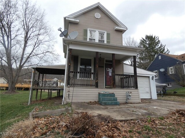 view of front of home with covered porch, a front yard, concrete driveway, and a garage