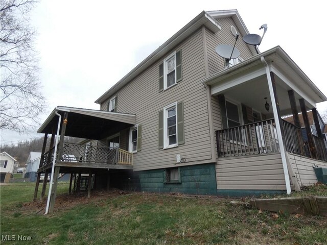 view of side of property with stairway and a lawn