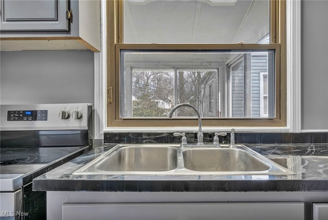 kitchen featuring a sink, dark countertops, and stainless steel electric stove