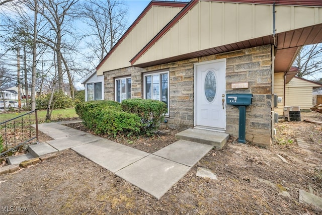 entrance to property with stone siding and central AC