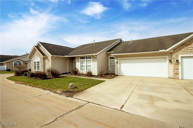 ranch-style home with stone siding, roof with shingles, concrete driveway, an attached garage, and a front lawn