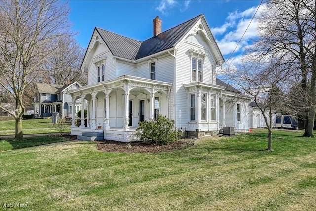 back of property featuring a porch, a yard, and cooling unit