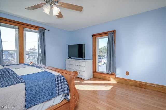 bedroom featuring baseboards, ceiling fan, and light wood-style floors