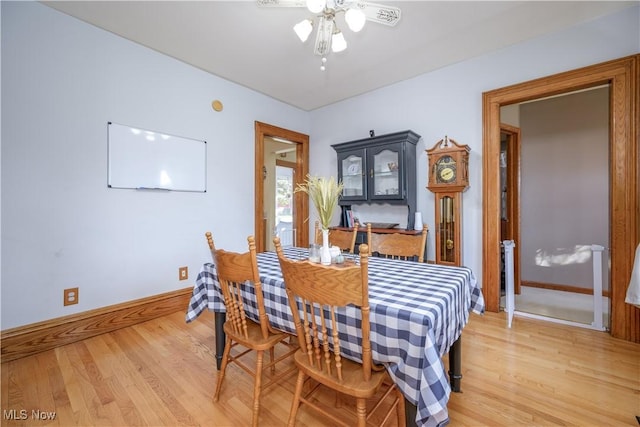dining area featuring ceiling fan, baseboards, and light wood finished floors
