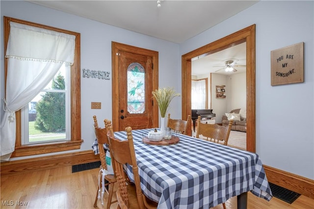 dining area featuring visible vents, plenty of natural light, and wood finished floors