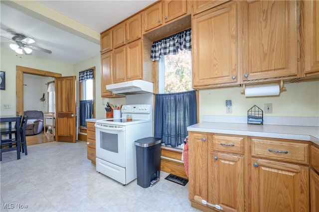kitchen featuring white electric range, light countertops, a ceiling fan, and under cabinet range hood