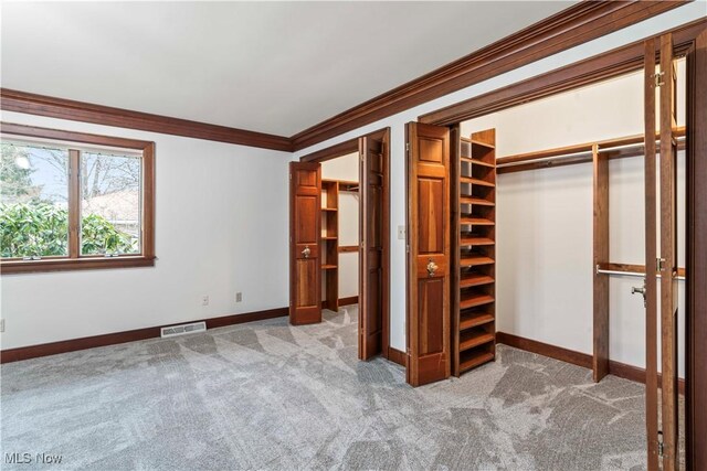 8187 N Lima Rd, Poland, OH 44514 - unfurnished bedroom featuring light colored carpet, crown molding, baseboards, and multiple closets