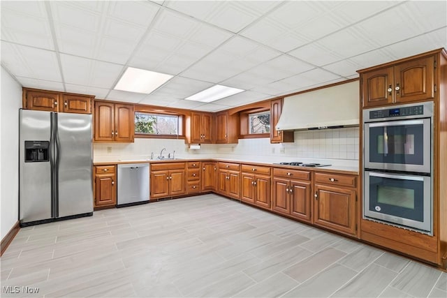 8187 N Lima Rd, Poland, OH 44514 - kitchen with appliances with stainless steel finishes, light countertops, brown cabinetry, a sink, and backsplash