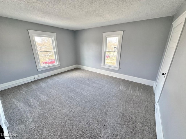 unfurnished bedroom with baseboards, multiple windows, and carpet