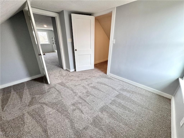 unfurnished bedroom with baseboards, carpet floors, and vaulted ceiling