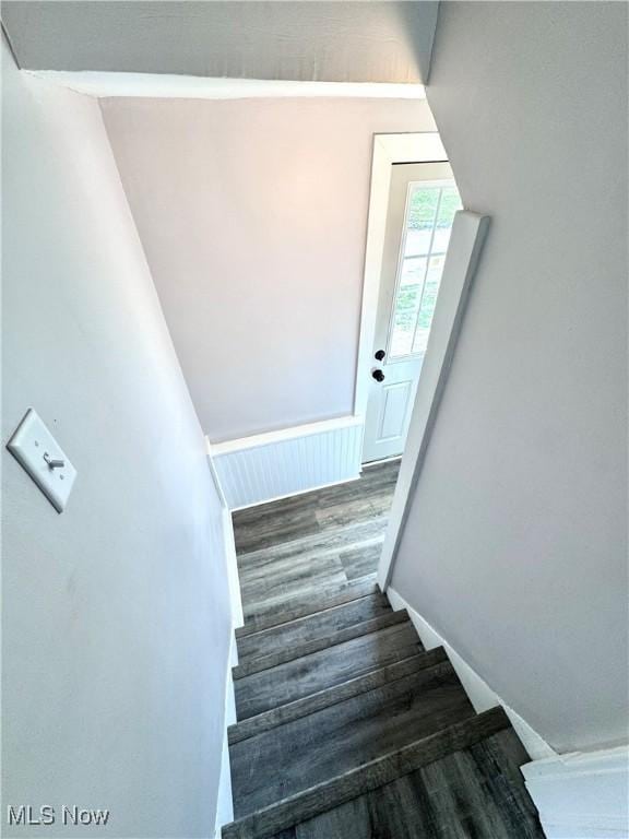 stairway with baseboards and wood finished floors