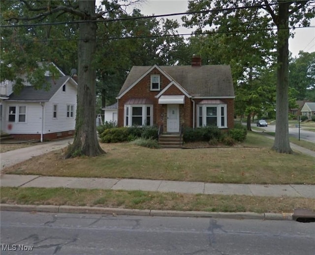 760 Babbitt Rd, Euclid, OH 44123 - view of front facade with a chimney, brick siding, and a front lawn