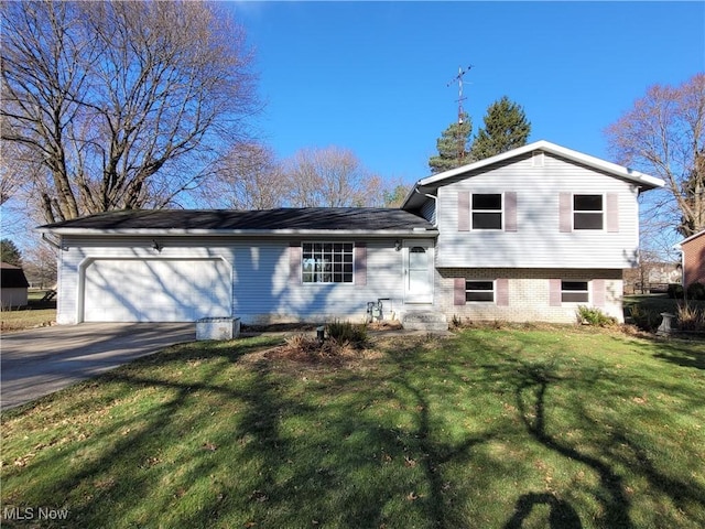 10360 Rischel Rd, Wadsworth, OH 44281 - split level home featuring a front lawn, a garage, brick siding, and concrete driveway