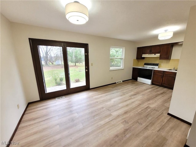 10360 Rischel Rd, Wadsworth, OH 44281 - kitchen with light countertops, visible vents, light wood-style flooring, white electric range, and under cabinet range hood