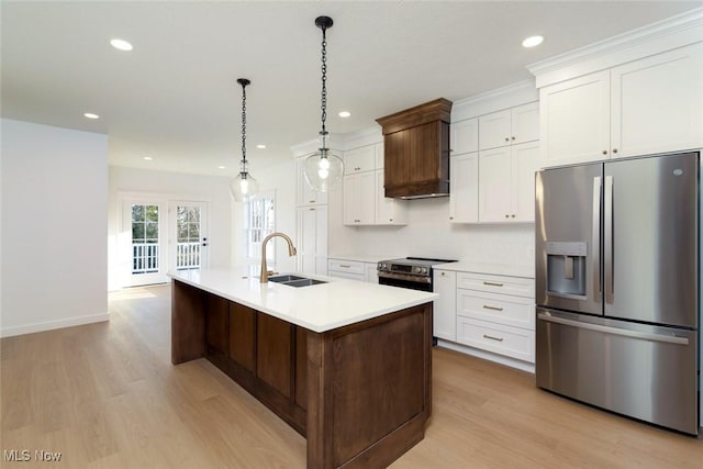 kitchen with light countertops, custom range hood, a center island with sink, a sink, and appliances with stainless steel finishes