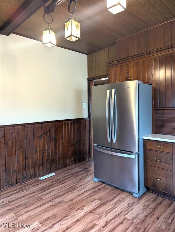 11154 Edgerton Rd, North Royalton, OH 44133 - kitchen featuring freestanding refrigerator, light wood-style flooring, a wainscoted wall, wood walls, and a wooden ceiling with exposed beams