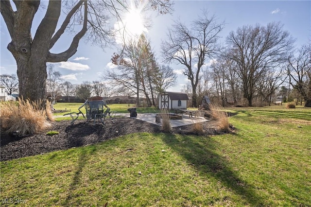 view of yard featuring an outbuilding, a storage unit, and a patio area