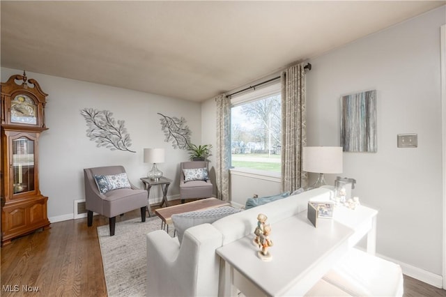 living room featuring baseboards, visible vents, and wood finished floors