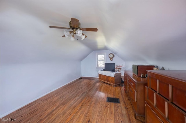 additional living space with lofted ceiling, baseboards, visible vents, a ceiling fan, and wood finished floors