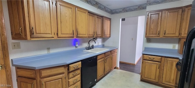 712 Circle Dr, Belpre, OH 45714 - kitchen with light countertops, light floors, a sink, black appliances, and brown cabinetry