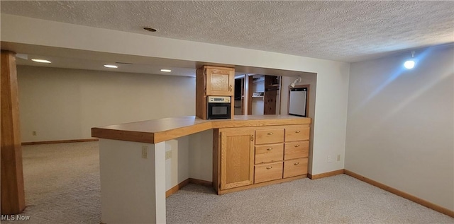 712 Circle Dr, Belpre, OH 45714 - kitchen with light carpet, baseboards, a peninsula, and oven