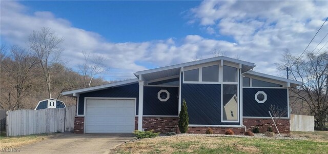 712 Circle Dr, Belpre, OH 45714 - mid-century inspired home with brick siding, a garage, concrete driveway, and fence