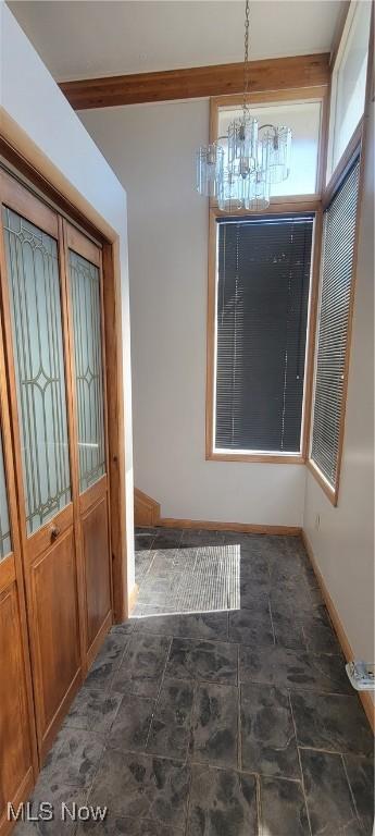 712 Circle Dr, Belpre, OH 45714 - unfurnished dining area with baseboards, a chandelier, and stone finish flooring