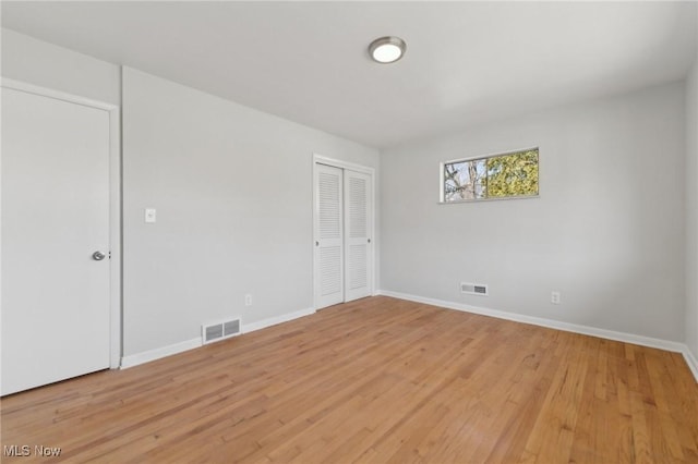 unfurnished room featuring light wood finished floors, baseboards, and visible vents