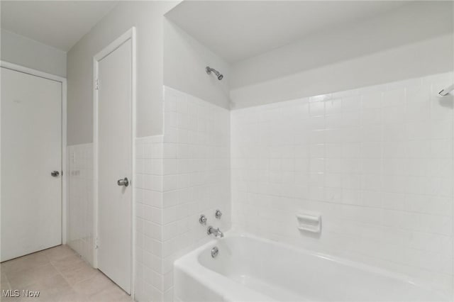 full bathroom with tile patterned floors, shower / tub combination, tile walls, and wainscoting